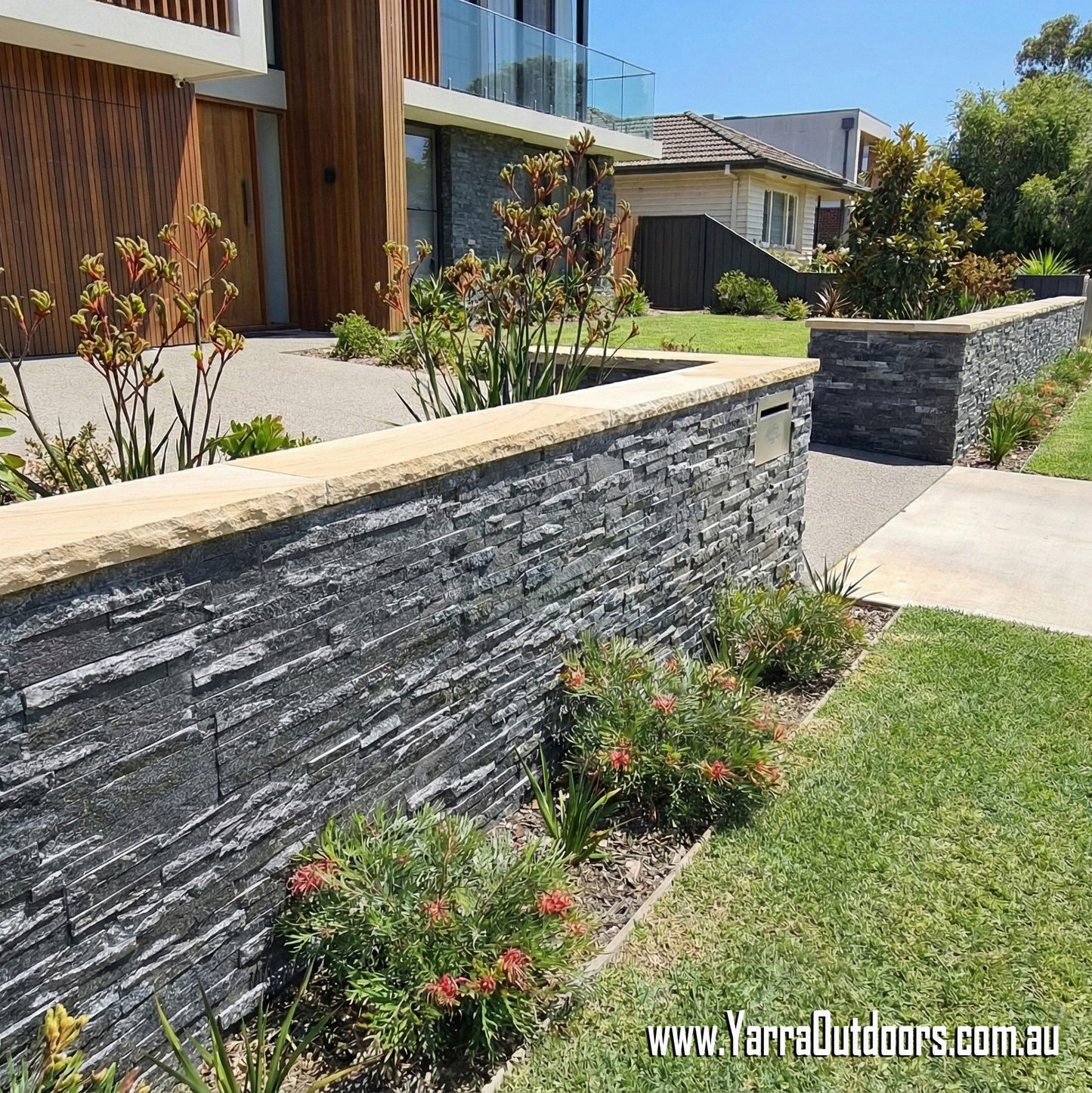 Black quartz stack stone cladding installed on modern boundary wall
